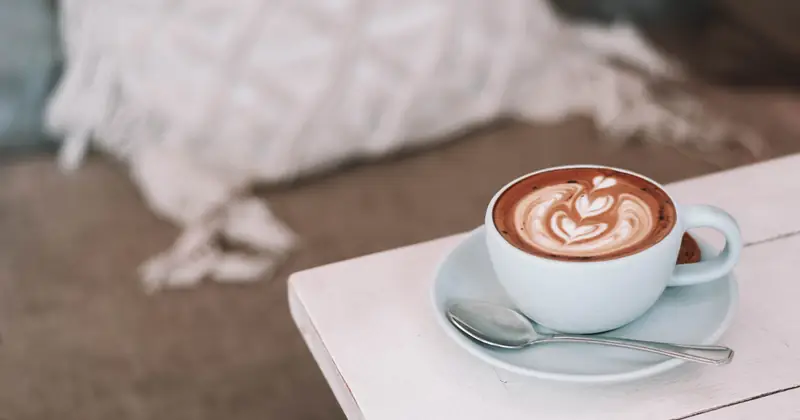 Latte art in a white cup on a café table.
