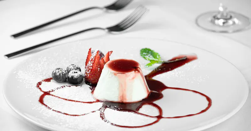 Stock photograph of a bright dessert with berries and mint.